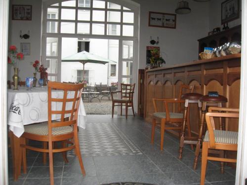 a dining room with a table with chairs and an umbrella at Pension Šejko in Horní Planá