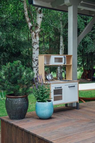 a outdoor kitchen with two potted plants on a wooden deck at Brzozowy Domek in Jarosławiec