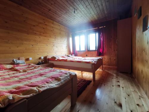 a bedroom with two beds in a wooden cabin at Uvac Griffon in Nova Varoš