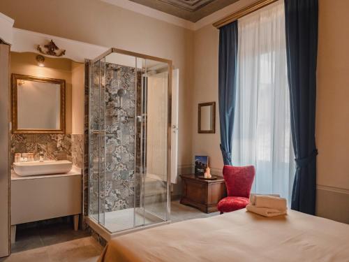 a bathroom with a shower and a bed and a sink at Palazzo dei Pavoni, Relais di Charme in LʼAquila