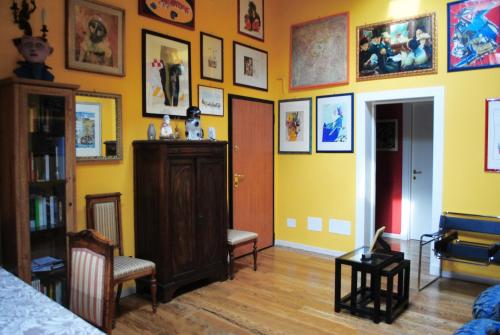 a room with a yellow wall with pictures on it at Bed & Breakfast Margherita in Bologna