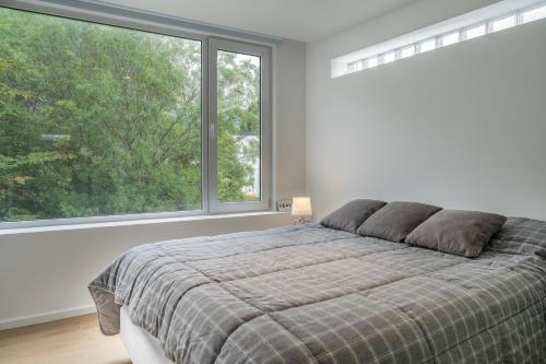1 dormitorio con cama y ventana grande en Temporales Ushuaia - Ilaia en Ushuaia