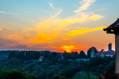 a sunset view of a town in the forest at Hotel Am Siebersturm in Rothenburg ob der Tauber