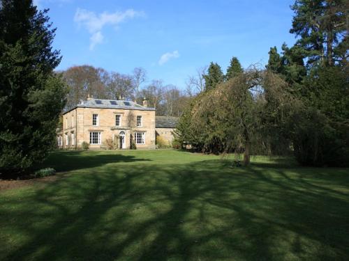 an old house with a large yard with trees at Burnhopeside Hall in Lanchester