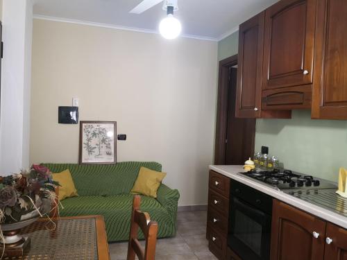 un salon avec un canapé vert dans une cuisine dans l'établissement Corso Roma, à Cirò Marina