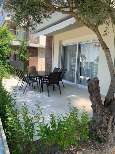 a patio with a table and chairs and a tree at Elia Luxury Maisonettes in Siviri