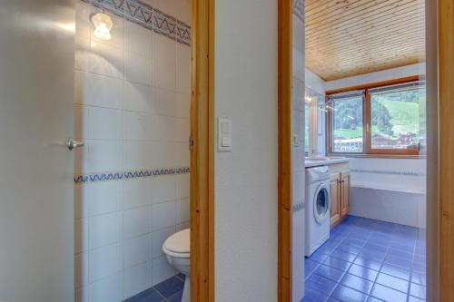 La salle de bains est pourvue de toilettes et d'un lave-linge. dans l'établissement Inukshuk Apartment - Snow and Trek, à Morzine