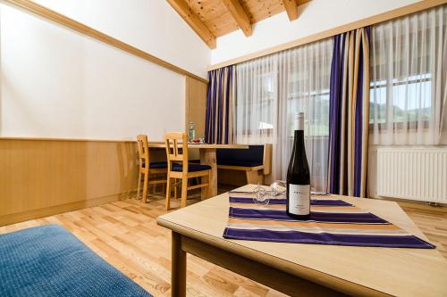 a bottle of wine on a table in a room at Hotel Langeck in Maria Alm am Steinernen Meer