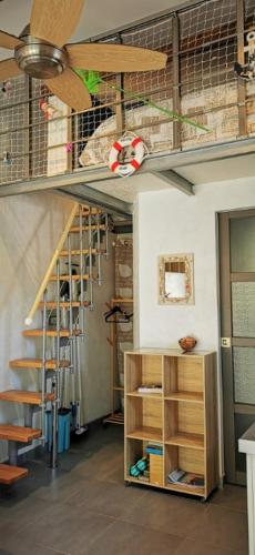 une chambre avec un escalier en colimaçon et une étagère. dans l'établissement STUDIO MEZZANINE 2/3 Personnes, à La Teste-de-Buch
