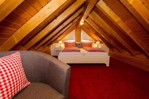 Habitación en el ático con cama y silla en Gästehaus Trostelhof, en Salem