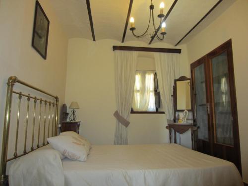 um quarto com uma cama e um lustre em Cortijo "Era Grande 1" em Córdoba