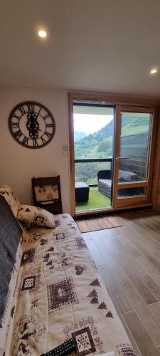 a bedroom with a bed and a large window at Studio Uissan pour 5 personnes à côté des pistes in LʼHuez