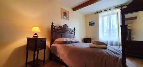 Un dormitorio con una cama y una lámpara y una ventana. en La maison de mon enfance ! Au cœur du Minervois !, en Félines-Minervois