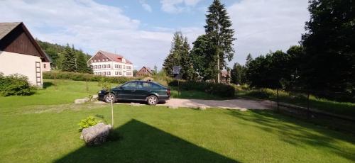 a car parked in the yard of a house at Chata Ondrášek in Bedřichov