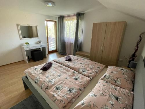 1 Schlafzimmer mit 2 Betten, einem Schreibtisch und einem Spiegel in der Unterkunft Aria Room - Rastoke in Slunj
