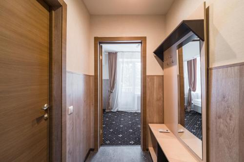 a hallway with a mirror and a door to a room at VO Hotel in Moscow