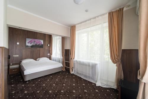 a bedroom with a bed and a large window at VO Hotel in Moscow