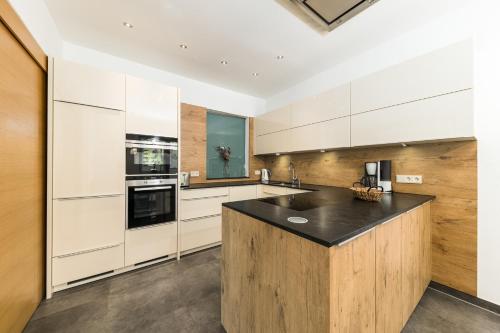 a kitchen with white cabinets and a black counter top at Apartmenthotel Sonnenhof in Maria Alm am Steinernen Meer