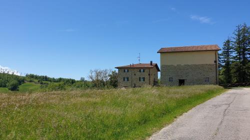 an old building on a hill next to a dirt road at Agriturismo Il Casone in San Benedetto Val di Sambro