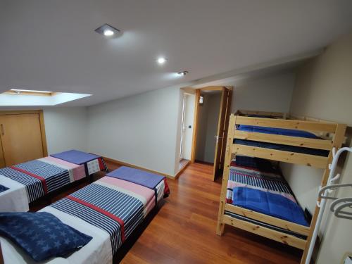 two bunk beds in a room with wooden floors at Rapadouro in Cangas de Morrazo