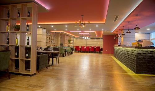 a restaurant with tables and chairs and a bar at Hotel Sonoma in Kosovo Polje