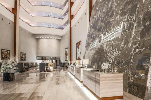 a large lobby with a large painting on the wall at Bay La Sun Hotel and Marina - Emaar King Abdullah Economic City in King Abdullah Economic City