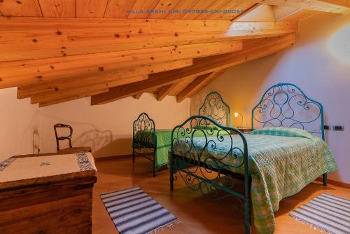 een slaapkamer met een bed in een kamer met houten plafonds bij Villa Archi in Colico