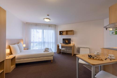 a hotel room with a bed and a chess board at The Originals Residence, Kosy Appart'hotels Troyes City & Park in Troyes