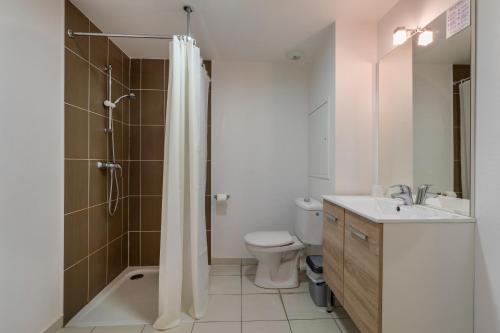 een badkamer met een douche, een toilet en een wastafel bij The Originals Residence, Kosy Appart'hotels Troyes City & Park in Troyes
