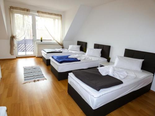 three beds in a room with a window at SUNNYHOME Monteurwohnungen und Apartments in Bodenwöhr in Bodenwöhr