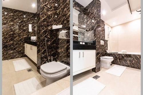 a bathroom with a toilet and a black marble wall at Downtown Cozy Home + partitioned living room in Dubai