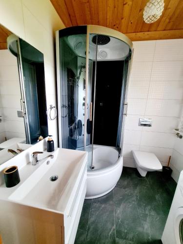 a bathroom with a tub and a sink and a toilet at Letniskowy domek z Bali in Myszyniec