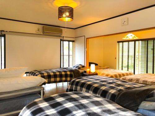 a room with three beds in a room with windows at THE HIGHEST VILLA IZUMI - Vacation STAY 07935v in Nakatsugawa