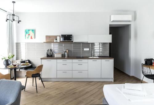 a kitchen with white cabinets and a table at Apartments Dolac in Rijeka