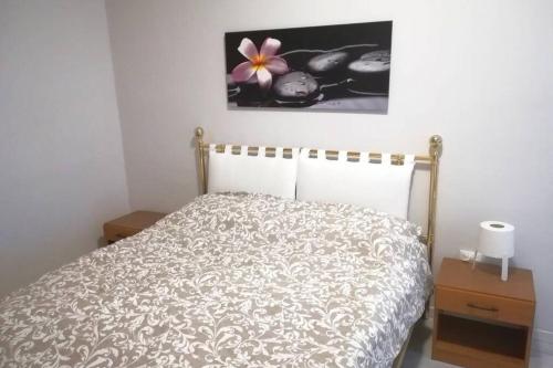 1 dormitorio con 1 cama con una flor en la pared en Casa Vacanze La CartolinA, en Trieste