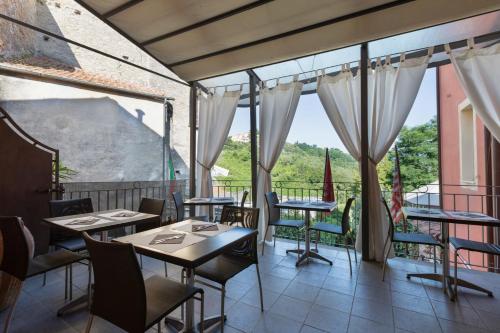 a restaurant with tables and chairs and large windows at Hotel Al Convento in Vezzano Ligure