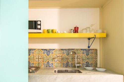 cocina con fregadero y estante amarillo en Nuvole Residenza by Wonderful Italy en Palermo