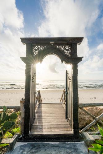 an open door to the beach with the sun shining at Casa Paradis Boutique Hotel in Jambiani
