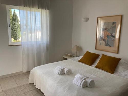 a bedroom with a white bed with towels on it at Typical TM Flat with a Terrace and Sea View in VSR in Porches