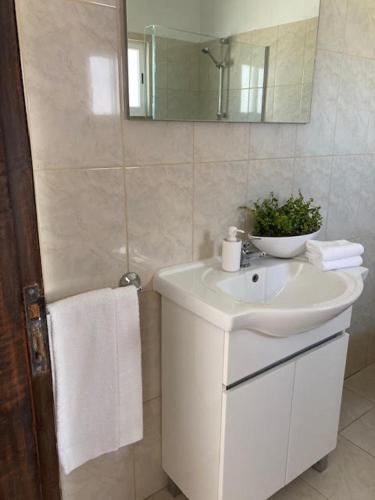 a white bathroom with a sink and a mirror at Typical TM Flat with a Terrace and Sea View in VSR in Porches