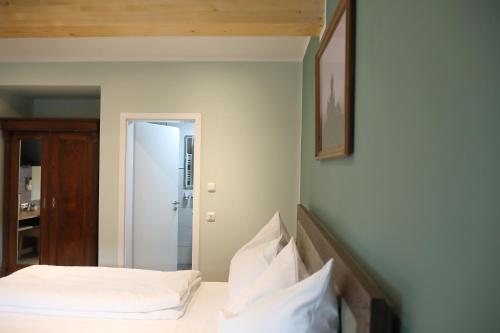 a bedroom with a bed with white sheets and pillows at Pension Moselvilla 1900 in Cochem