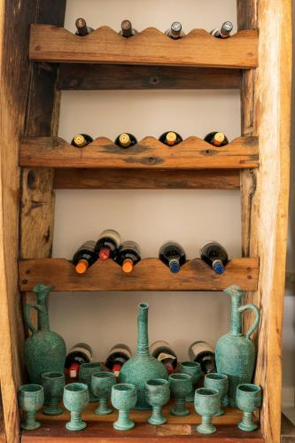 a bunch of wine bottles in a wooden shelf at Casa Paradis Boutique Hotel in Jambiani