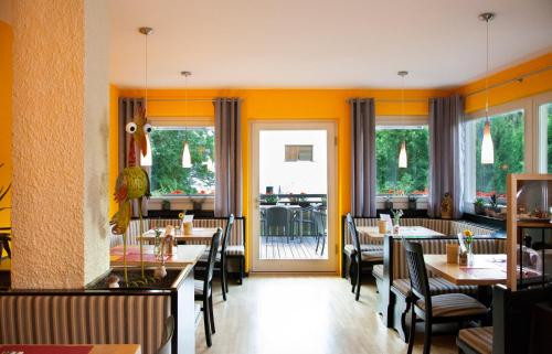 a dining room with tables and chairs and windows at Villa Gottfried B&B in Eggen