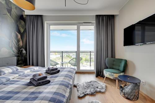 Un dormitorio con una cama y un televisor y una ventana. en Bastion Wałowa by Blue Mandarin, en Gdansk