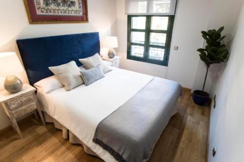 - une chambre avec un grand lit blanc et une tête de lit bleue dans l'établissement Chamberí I, à Madrid