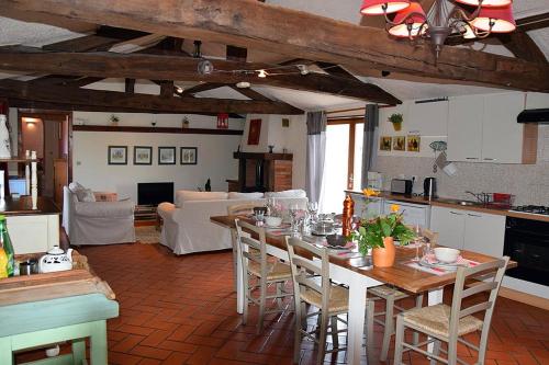 a kitchen and living room with a table and chairs at Gîte de La Pomerie in Chiché
