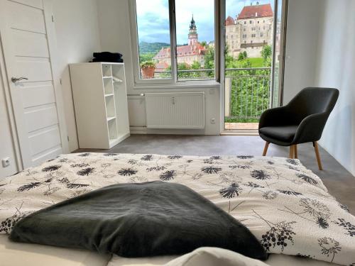 1 dormitorio con 1 cama, 1 silla y 1 ventana en CK-Apartment, en Český Krumlov