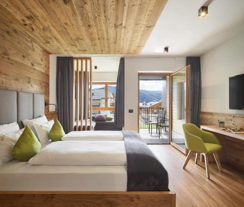 a bedroom with a large bed and a balcony at Hotel Sport in Colfosco