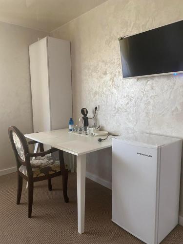 a white table with a chair and a white refrigerator at DALIM in Duliby