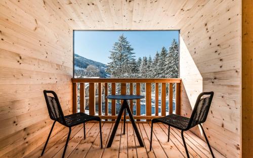a table and two chairs on a balcony with a window at Lichtung Woldererhof Auszeit in Racines